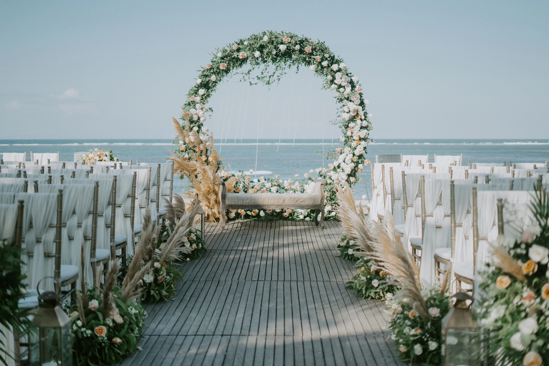 Wide shot of floral arch near the sea for a wedding ceremony during daytime